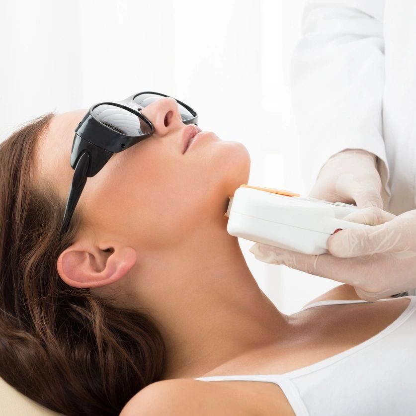 Woman receiving a laser treatment on her neck.